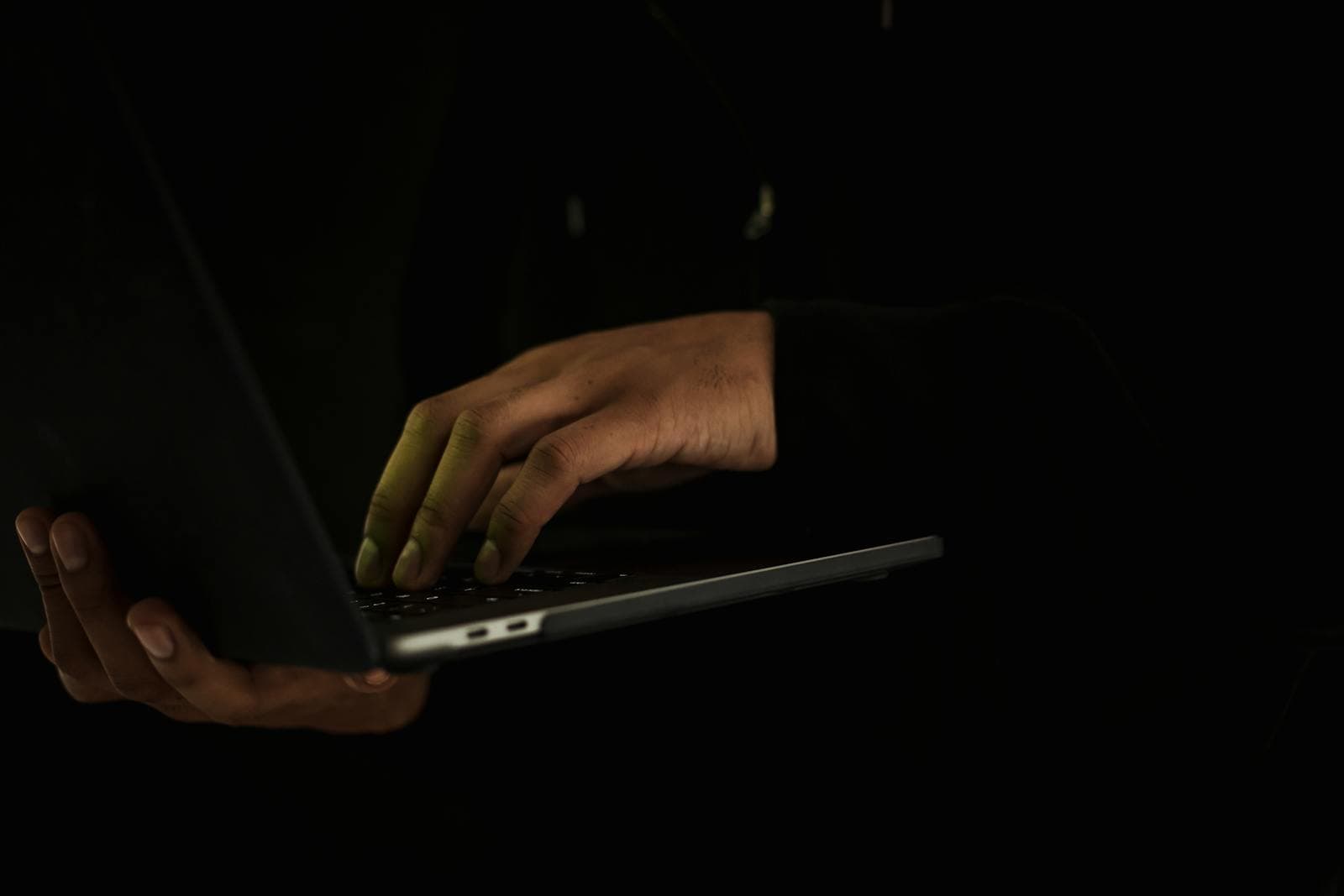 Hands typing on a laptop in a darkened room, the cinematic shorthand for a cybersecurity threat that Silicon Valley turned into a recurring character