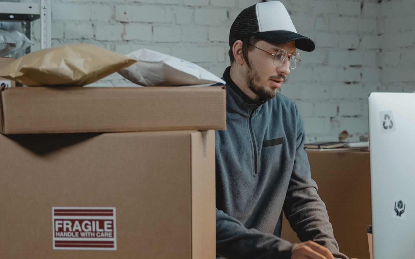 Operations employee at a computer surrounded by shipping cartons